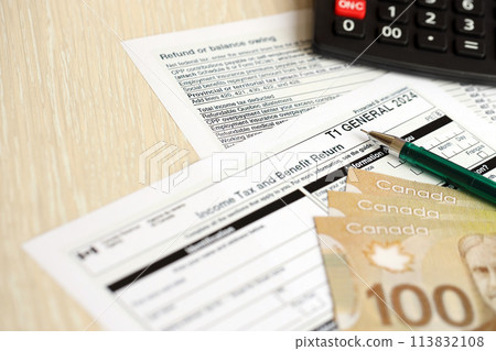 Canadian T1 General tax form Income tax and benefit return lies on table with canadian money bills close up. Taxation and annual accountant paperwork in Canada Canadian T1 General tax form Income tax and benefit return lies on table with canadian money bills close up. Taxation and annual accountant paperwork in Canada 113832108