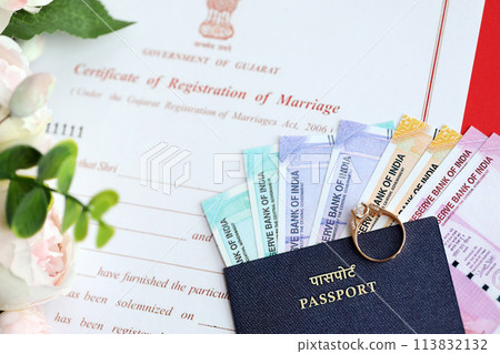 Indian Certificate of registration of marriage blank document and wedding ring with rupiah money on table close up 113832132