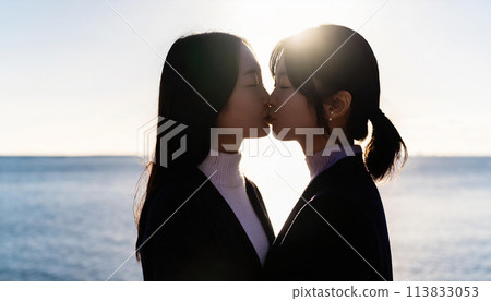 年輕女子在海灘上接吻的背光照片 年輕女子在海灘上接吻的背光照片 113833053