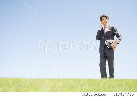 Young businessman talking outdoors 113834750