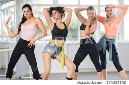 Female dancers in stiletto dance class striking choreographed poses 113835198