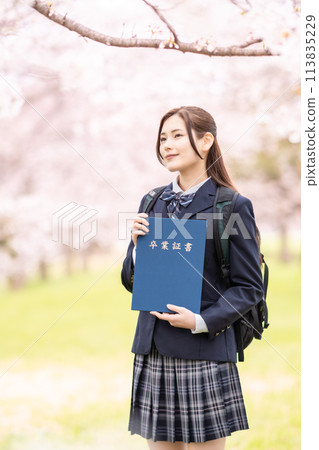 一名女高中生在盛開的櫻花叢中慶祝畢業典禮。 113835229