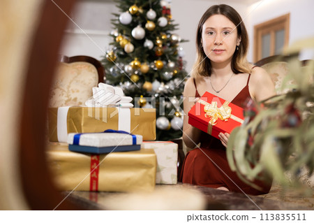 Happy young woman prepares Christmas presents 113835511