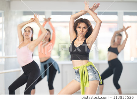 During lesson, woman learn to move and perform dance in heels with women companions 113835526
