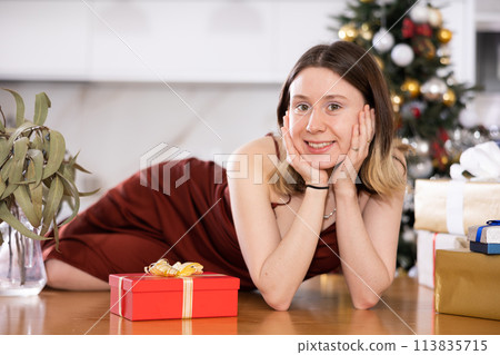Woman poses with Christmas presents at home Woman poses with Christmas presents at home 113835715