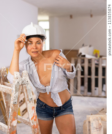 Tempting woman in revealing attire posing in construction site Tempting woman in revealing attire posing in construction site 113835874