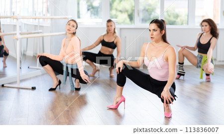 Female instructor performing graceful sass dance at group class Female instructor performing graceful sass dance at group class 113836007