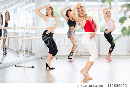 Female instructor performing graceful sass dance movements during group class Female instructor performing graceful sass dance movements during group class 113836053