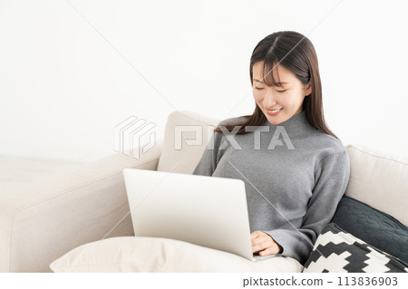 觀看一台便攜式計算機的婦女在屋子裡 113836903