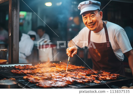 Happy Asian chef cooking traditional food on open fire in street market Happy Asian chef cooking traditional food on open fire in street market 113837535