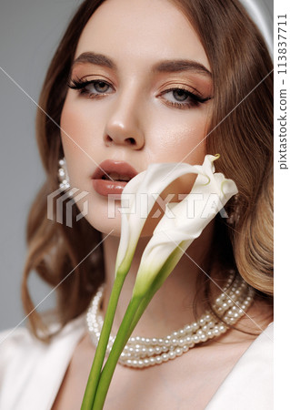 A woman with long brown hair and a white flower in her mouth A woman with long brown hair and a white flower in her mouth 113837711