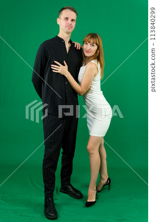 Young attractive business people in formal, black and white clothes. On a green background. High quality photo Young attractive business people in formal, black and white clothes. On a green background. High quality photo 113840299