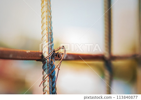 Fastening steel reinforcement with tying wire at a construction site, selective soft focus. 113840877