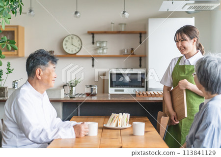 亞洲女大堂工作人員/女服務員在咖啡館/廚房為年長夫婦提供餐點 亞洲女大堂工作人員/女服務員在咖啡館/廚房為年長夫婦提供餐點 113841129