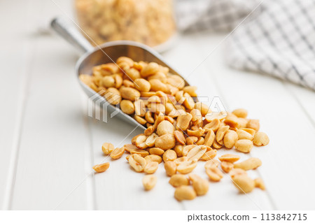 Salted roasted peanuts in scoop on kitchen table 113842715