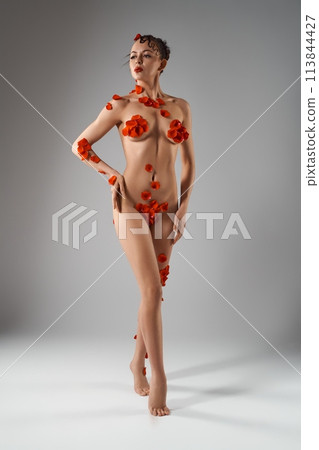 Sensual naked woman with petals in white studio 113844427