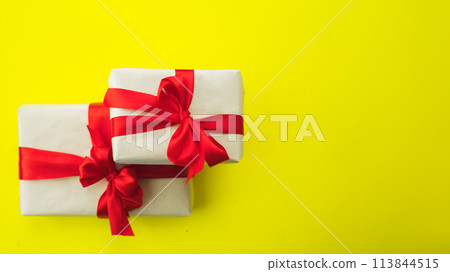 banner two gifts in brown craft paper and red ribbon with bow on yellow background banner two gifts in brown craft paper and red ribbon with bow on yellow background 113844515
