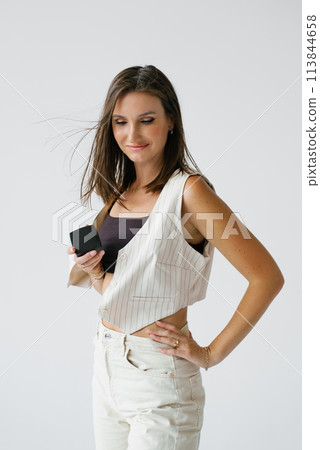 Young make-up artist woman holds decorative cosmetics on a white background Young make-up artist woman holds decorative cosmetics on a white background 113844658