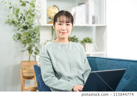 一位女士在客廳操作筆記型電腦 113844774