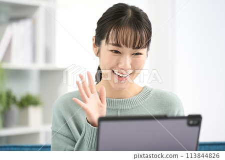 在平板電腦上進行視頻通話的女人 在平板電腦上進行視頻通話的女人 113844826