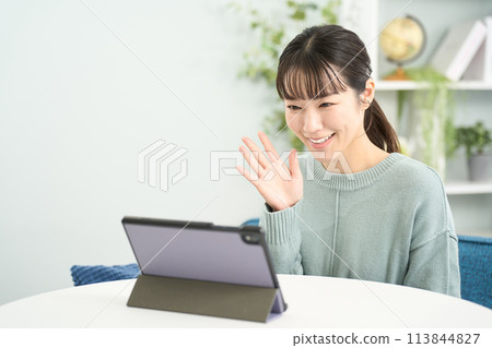 在平板電腦上進行視頻通話的女人 113844827