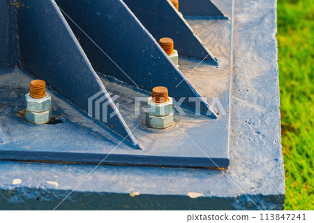 A metal billboard support fixed to a concrete foundation with studs and nuts. Construction, installation of metal structures, types of fasteners A metal billboard support fixed to a concrete foundation with studs and nuts. Construction, installation of metal structures, types of fasteners 113847241