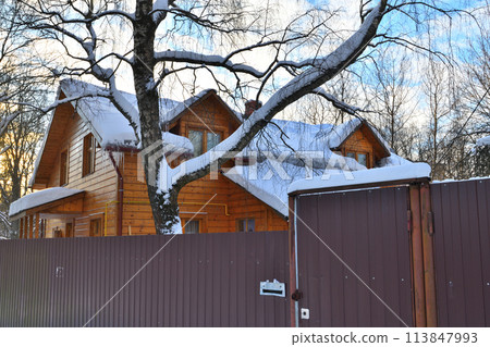 Wooden house in the snow behind a fence, Russia 113847993