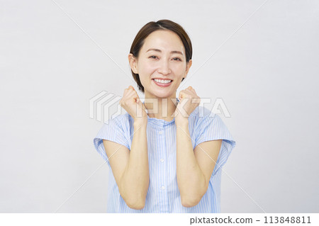 Middle-aged woman doing a guts pose White background Middle-aged woman doing a guts pose White background 113848811