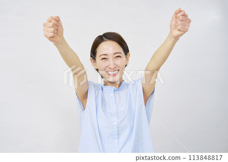 Middle-aged woman doing a guts pose White background 113848817