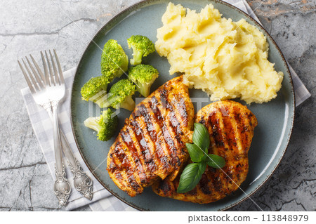 Roast breast grilled chicken with broccoli and mashed potatoes closeup on the plate. Horizontal top view 113848979