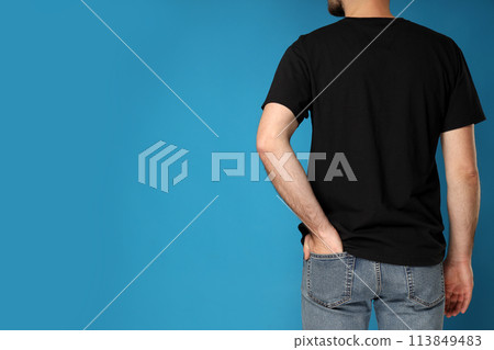 A young guy in a black t-shirt on a blue background 113849483