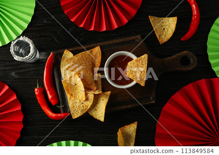 Nachos with tequila and chili pepper on a dark background 113849584