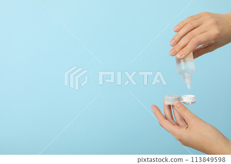 Contact lens liquid with lens container in hand Contact lens liquid with lens container in hand 113849598
