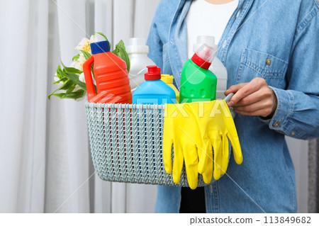 A basket with detergents in the hands of a woman 113849682