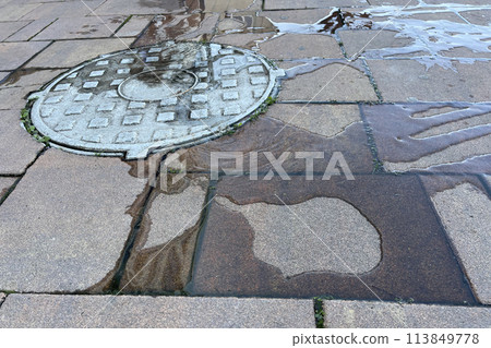 Metal hatch, drain drain with sewage. Water near the manhole on the street. Metal hatch, drain drain with sewage. Water near the manhole on the street. 113849778