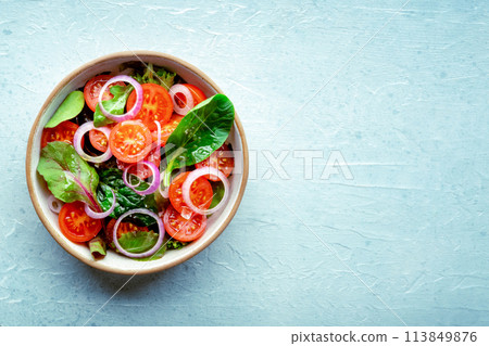 Salad with tomato, fresh leaves, and onions, overhead flat lay shot Salad with tomato, fresh leaves, and onions, overhead flat lay shot 113849876