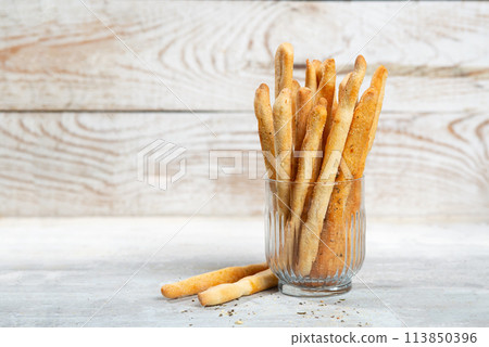 Grissini with herbs on a gray concrete background 113850396