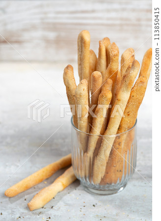 Grissini with herbs on a gray concrete background Grissini with herbs on a gray concrete background 113850415