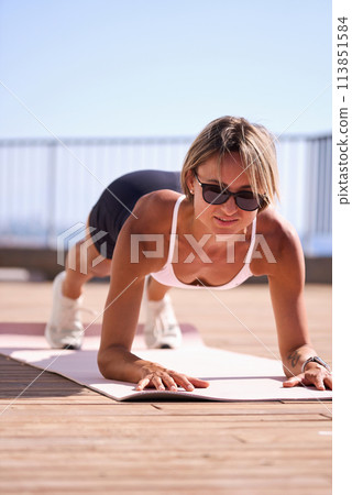 young caucasian woman in plank position, exercising outdoors. stretch whole body, lead healthy 113851584