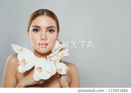 Glorious model woman with natural make-up, healthy skin and white flower. Female beauty, cosmetology 113851866