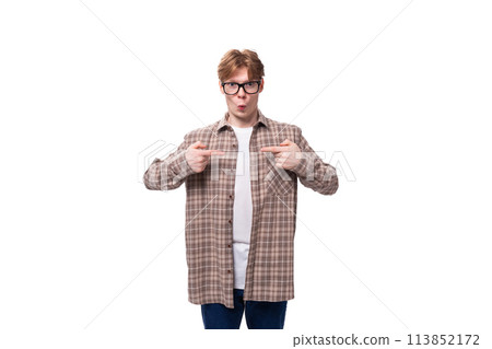 a young handsome red-haired guy in a plaid shirt is actively gesturing against the background with 113852172