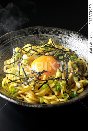 Hot oil soba noodles topped with egg yolk, shredded seaweed, and green onions photographed against a black background Hot oil soba noodles topped with egg yolk, shredded seaweed, and green onions photographed against a black background 113853080