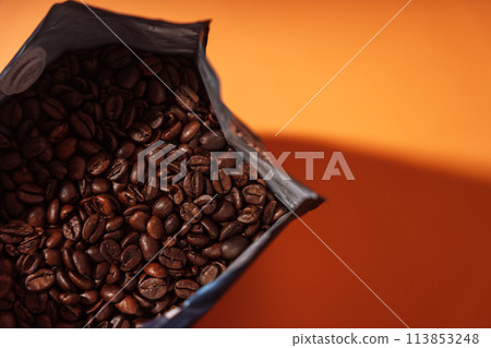 Zip bag with coffee beans close-up on an orange background 113853248