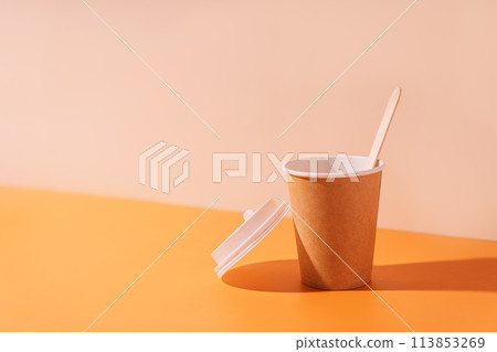 Empty paper cup with wooden spoon on beige background 113853269