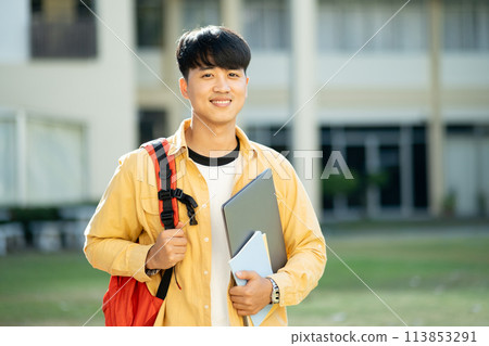 Smiling College Student with Laptop and Books on Campus 113853291