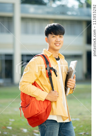 Smiling College Student with Laptop and Books on Campus Smiling College Student with Laptop and Books on Campus 113853292