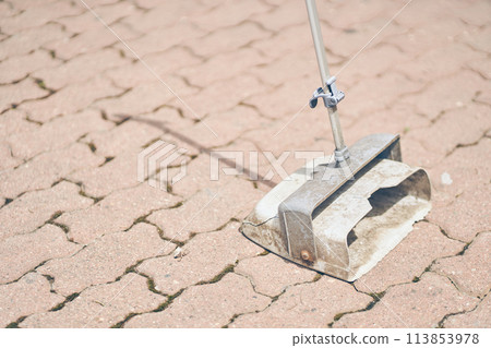 A dustpan on the background of street paving slabs. Cleaning dirt and dust from the streets of the city. With space to copy. High quality photo 113853978