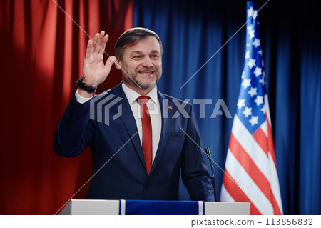 Happy mature male politician waving hand Happy mature male politician waving hand 113856832