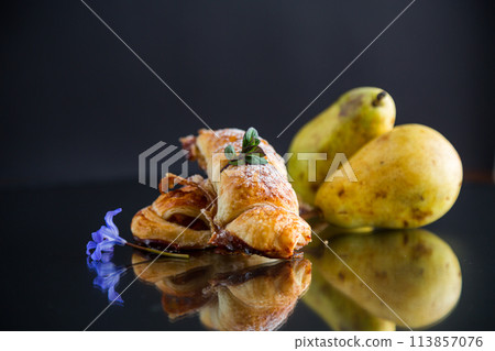 Sweet pastries, puff pastries with pears, isolated on black background Sweet pastries, puff pastries with pears, isolated on black background 113857076