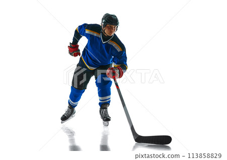 Dynamic photo of skilled hockey player precise stickhandling, his focus evident as he glide across ice against white studio background. 113858829